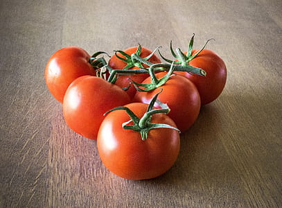 Six Orange Tomatoes Forming Triangle on Brown Surface thumbnail