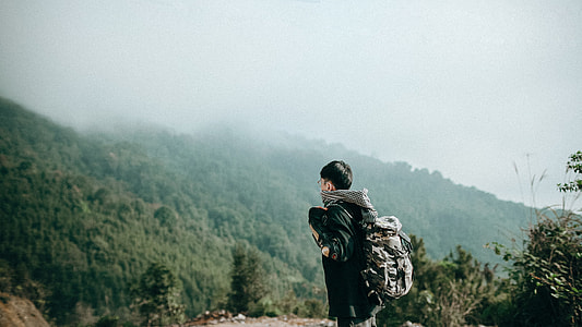 man standing near trees during daytime thumbnail