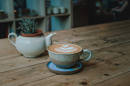 cup of coffee latte beside teapot thumbnail