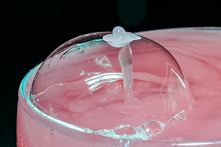 bubble on clear drinking glass filed with pink-colored beverage thumbnail