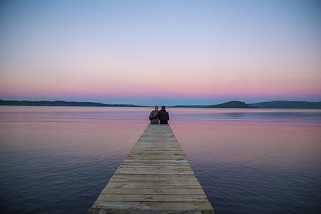 two person sitting on wooden dock thumbnail