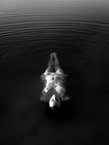 grayscale photo of woman floating on body of water thumbnail