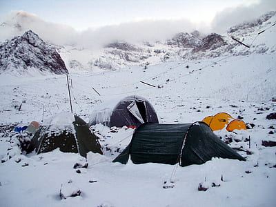 four camping tents on white snow mountain during daytime thumbnail
