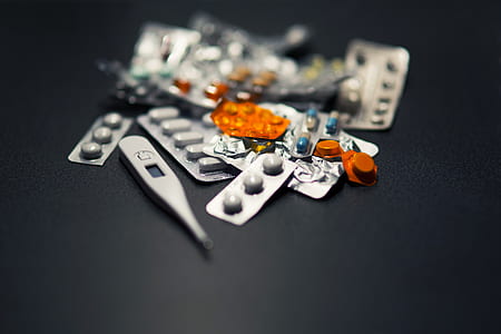 assorted medication pills and digital thermometer at black surface thumbnail