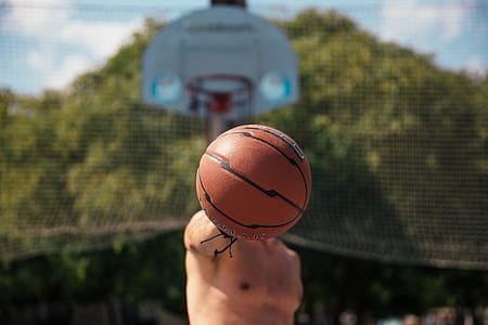A young caucasian man holding a basketball in his right hand in the basketball court thumbnail