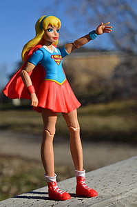 macro photograph of DC Super Hero Girls Supergirl action figure on gray wooden surface thumbnail