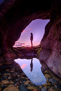 person standing near cave thumbnail