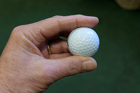 Hand holding golf ball thumbnail