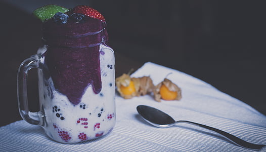 clear glass jar beside grey spoon on white textile thumbnail