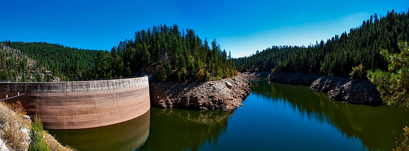 lake near trees and mountain under clear sky during daytime thumbnail