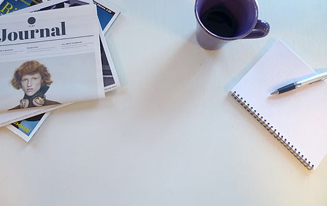 pen on notebook beside cup thumbnail