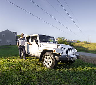 Man Standing Near White Jeep Wrangler Suv thumbnail