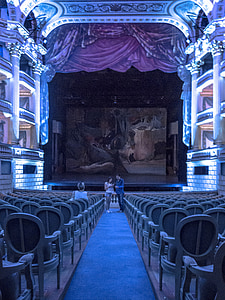 woman and man standing near stage in room thumbnail