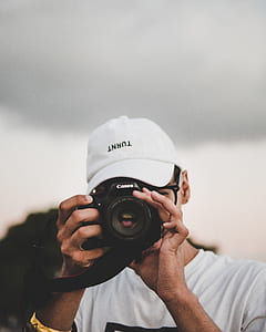 person using Canon DSLR camera thumbnail