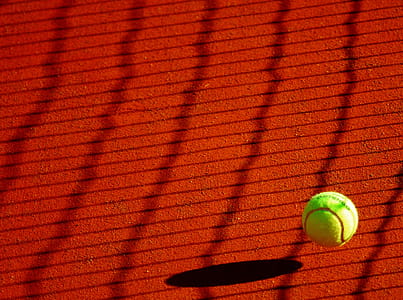 Green Tennis Ball on Red Floor during Sunny Day thumbnail