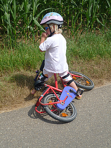 boy riding red bicycle on road thumbnail