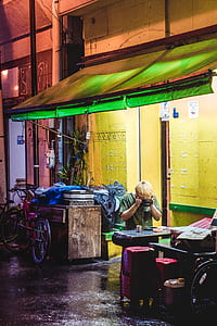 man in green shirt taking photo of blue table thumbnail