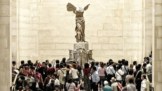 group of people gathering in front of gray concrete statue thumbnail