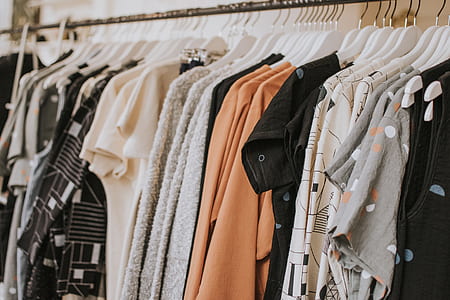 assorted-color-and-pattern clothes hanged on gray rack thumbnail