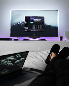 black flat screen TV on top of white wooden TV stand thumbnail