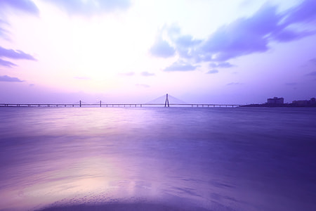 wide angle photo of suspension bridge under cloudy sky thumbnail