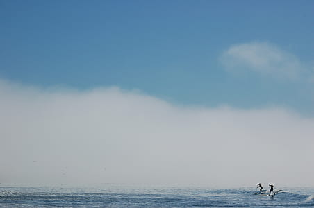 silhouette of two person on body of water during daytime thumbnail
