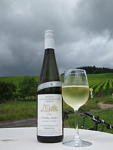 wine bottle beside wineglass on white table thumbnail