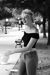 Grayscale Photo Of Woman Standing While Smiling thumbnail