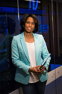 Woman in Teal Blazer Coat and Black Pants Holding A Tablet thumbnail