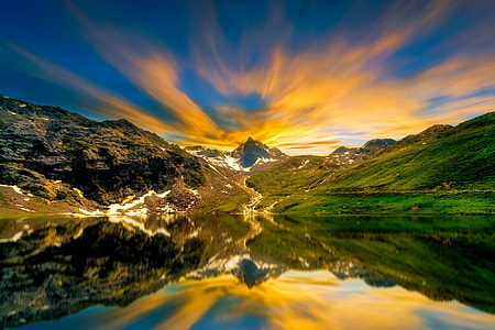 photo of body of water near green mountains during day time thumbnail
