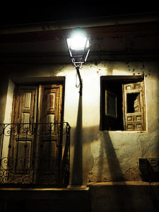 black wall lamp between brown wooden panel door and window thumbnail