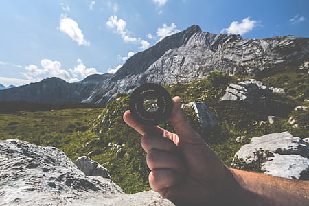 Person Holding Black Camera Lens Near Mountain thumbnail