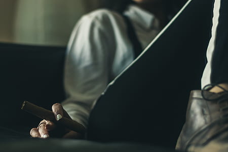 person sitting on sofa holding cigar thumbnail