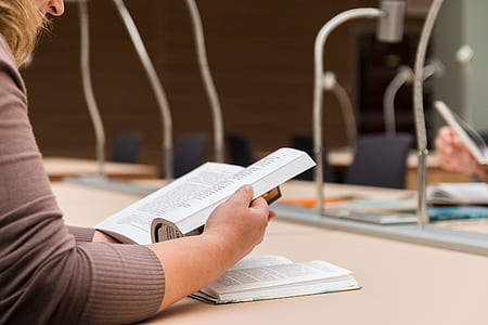 close-up photo of woman with gray long-sleeved shirt reading book thumbnail