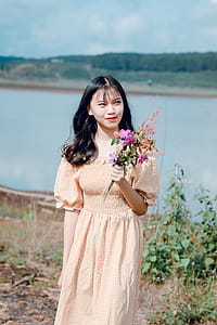 Woman Holding Purple Petaled Flowers thumbnail