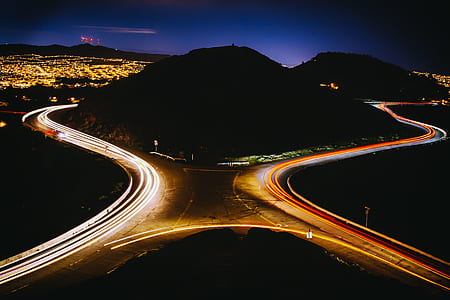 hill surrounded by asphalt road during nighttime timelapse photography thumbnail