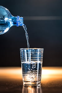 time lapse photo of water from bottle down to clear drinking glass thumbnail