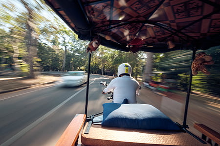 time lapse photography of person riding auto rickshaw on road thumbnail