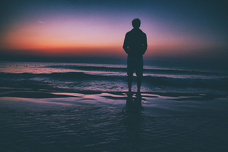 person standing at shore during golden hour thumbnail