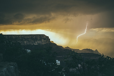 silhouette photography of lightning on rocky mountains thumbnail