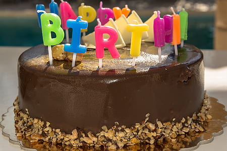 brown icing birthday cake with multicolored candles thumbnail