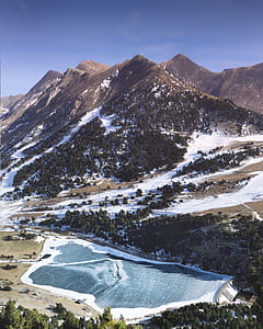 aerial photo of dam beside mountain range during daytime thumbnail