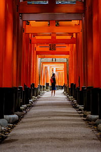 woman with red backpack walking on red tunnel with daytime thumbnail