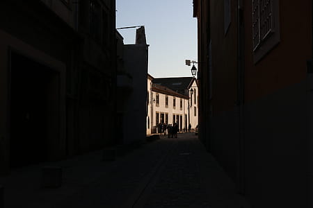 group of people gathering on street between buildings under clear blue sky thumbnail