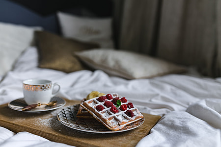 Breakfast in bed - waffles with raspberries and cup of coffee on the tray thumbnail