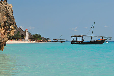 black wooden boat on blue body of water thumbnail