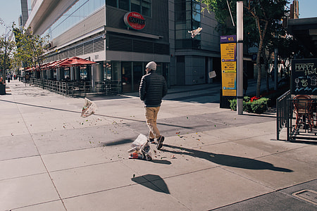 man standing on gray concrete flooring near commerical building thumbnail