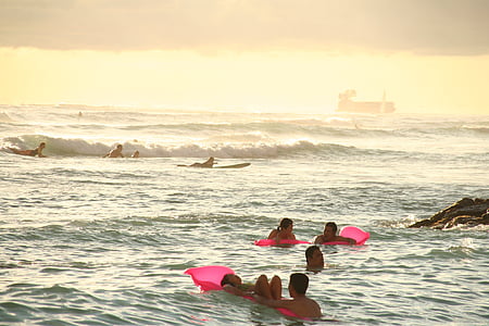 people swimming on the ocean during daytime thumbnail