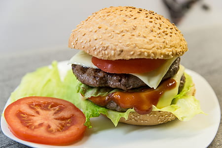 hamburger with sliced tomato and vegetable on white ceramic plate thumbnail