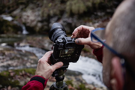 person wearing red sweater holding camera thumbnail